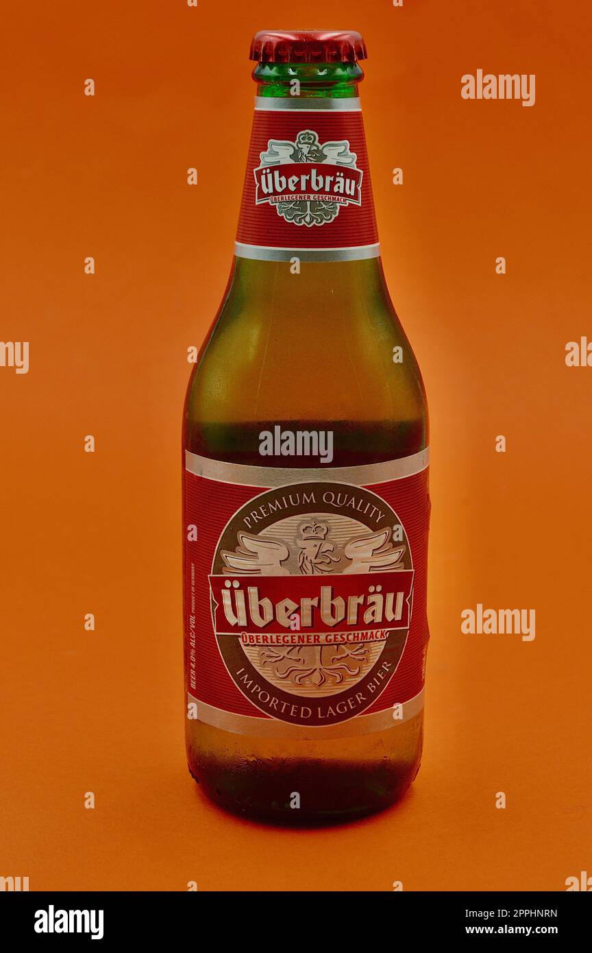 A closeup of a bottle of Uberbrau Premium lager against an orange background Stock Photo