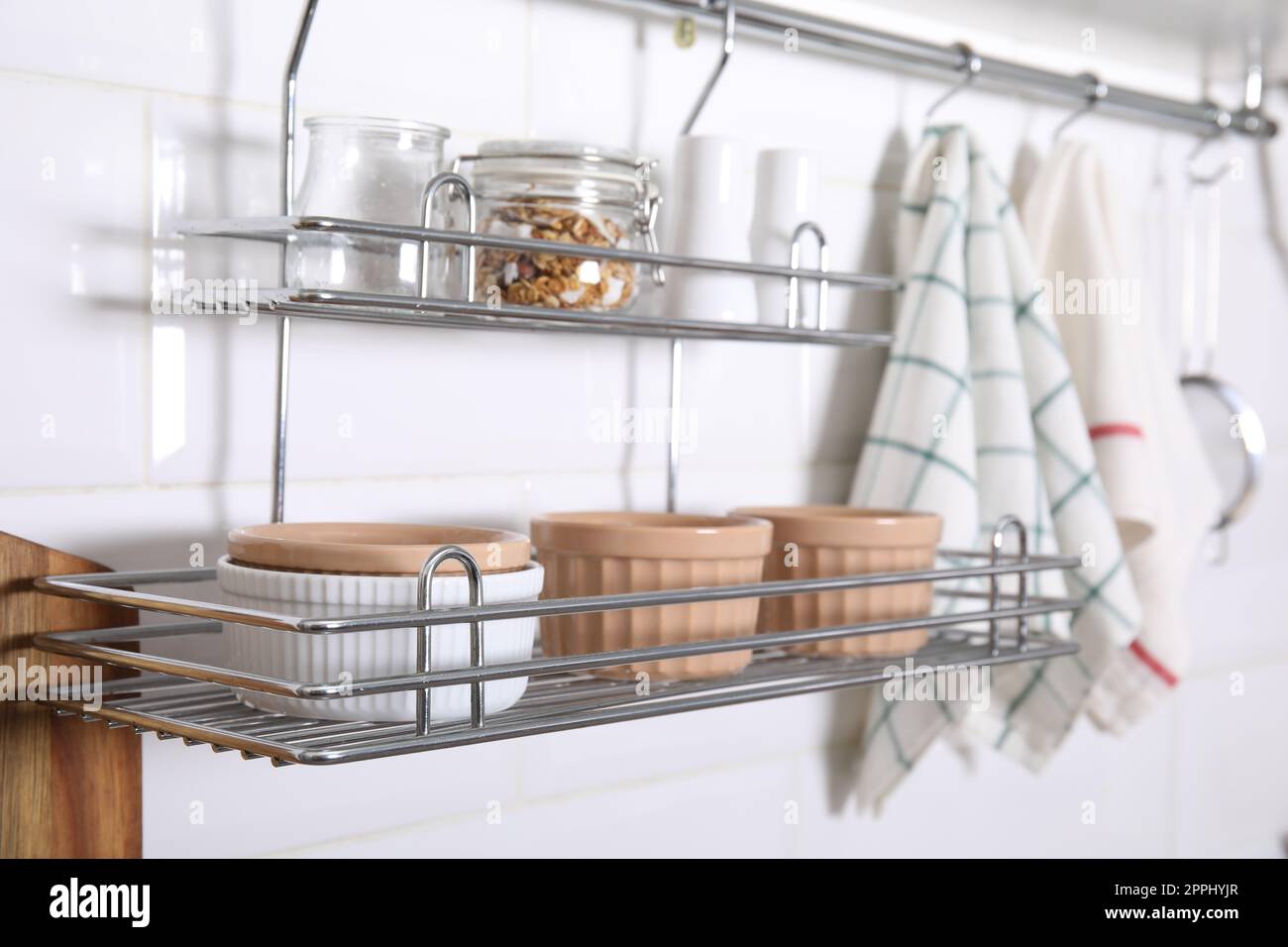 Many different ramekins on metal rack in kitchen Stock Photo