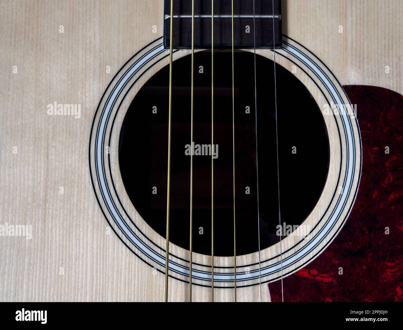 Close up shot of acoustic guitar. Strings, sound hole , bridge, pickguard Stock Photo