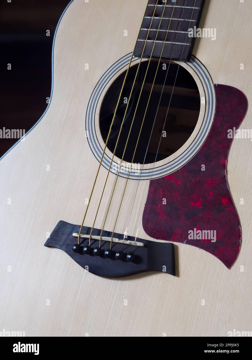 Close up shot of acoustic guitar. Strings, sound hole , bridge, pickguard Stock Photo