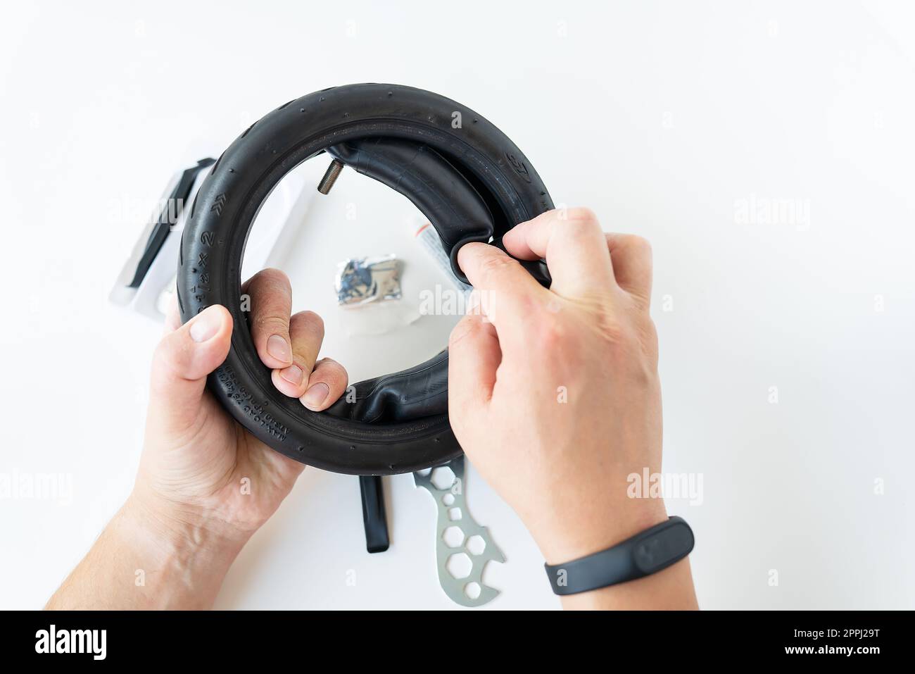 A man carefully looks at the carving of the tire of an electric scooter
