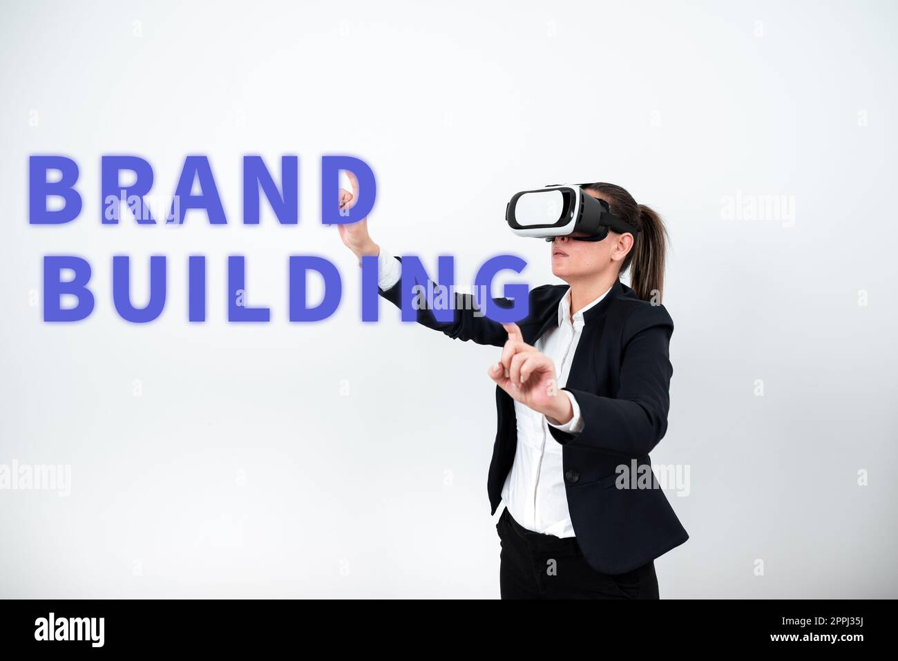 Conceptual display Brand Building. Business approach Develop a unique professional identity Personal product Woman Wearing Vr Glasses And Pointing On Important Messages With Both Hands Stock Photo