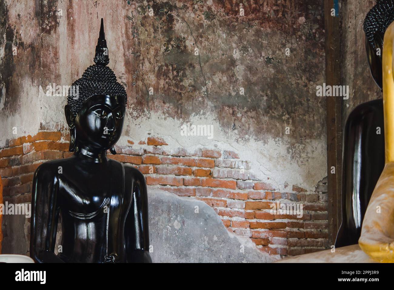 Black buddha statue with old walls in Thai temples Stock Photo