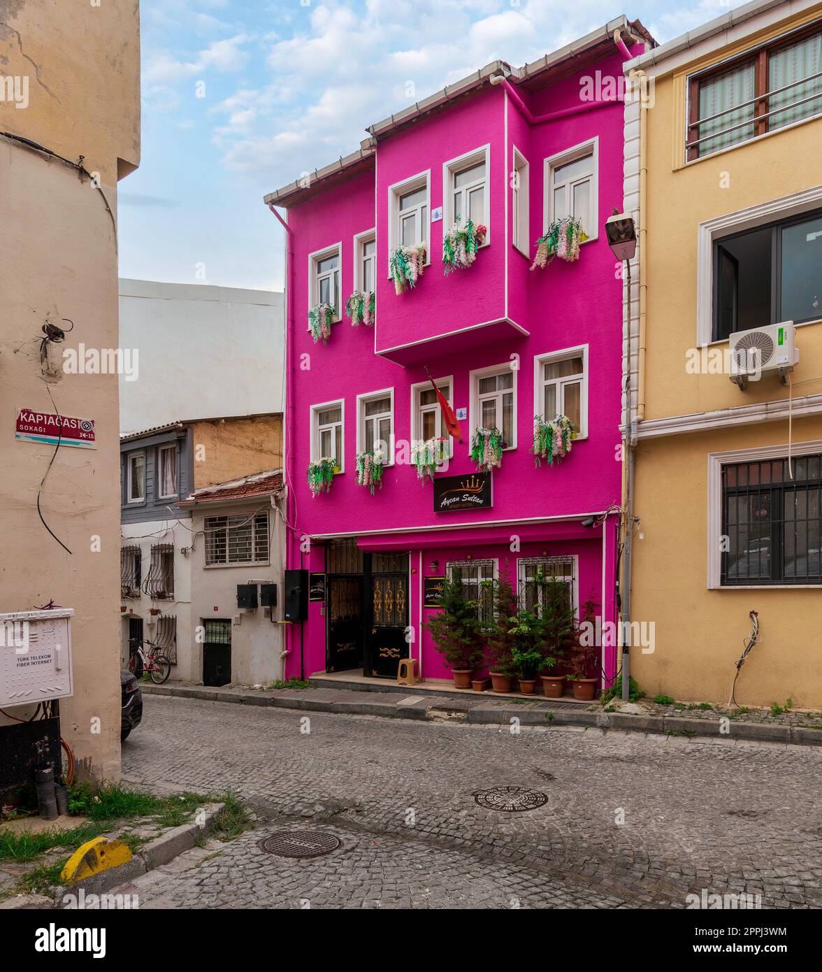 Cobblestone alley, with beautiful old houses painted in pink and yellow, suited in Fatih district, Istanbul Stock Photo