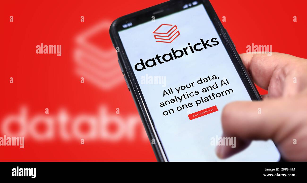 hand holding a phone with Databricks company web page on screen Stock Photo