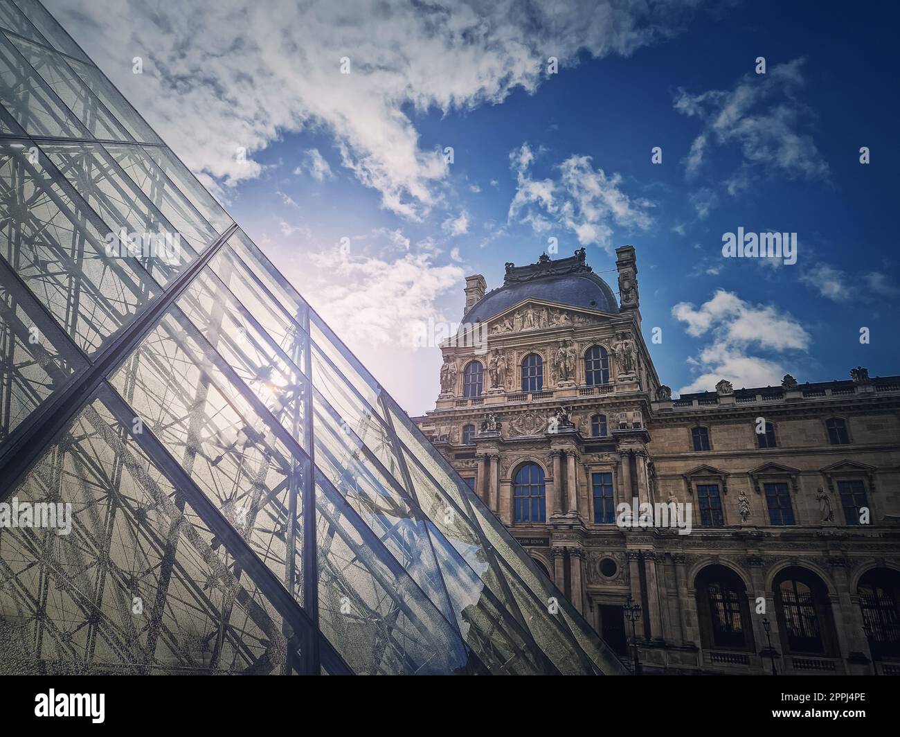 Louvre building, outdoors facade view of the famous museum palais with the modern glass pyramid in Paris, France Stock Photo