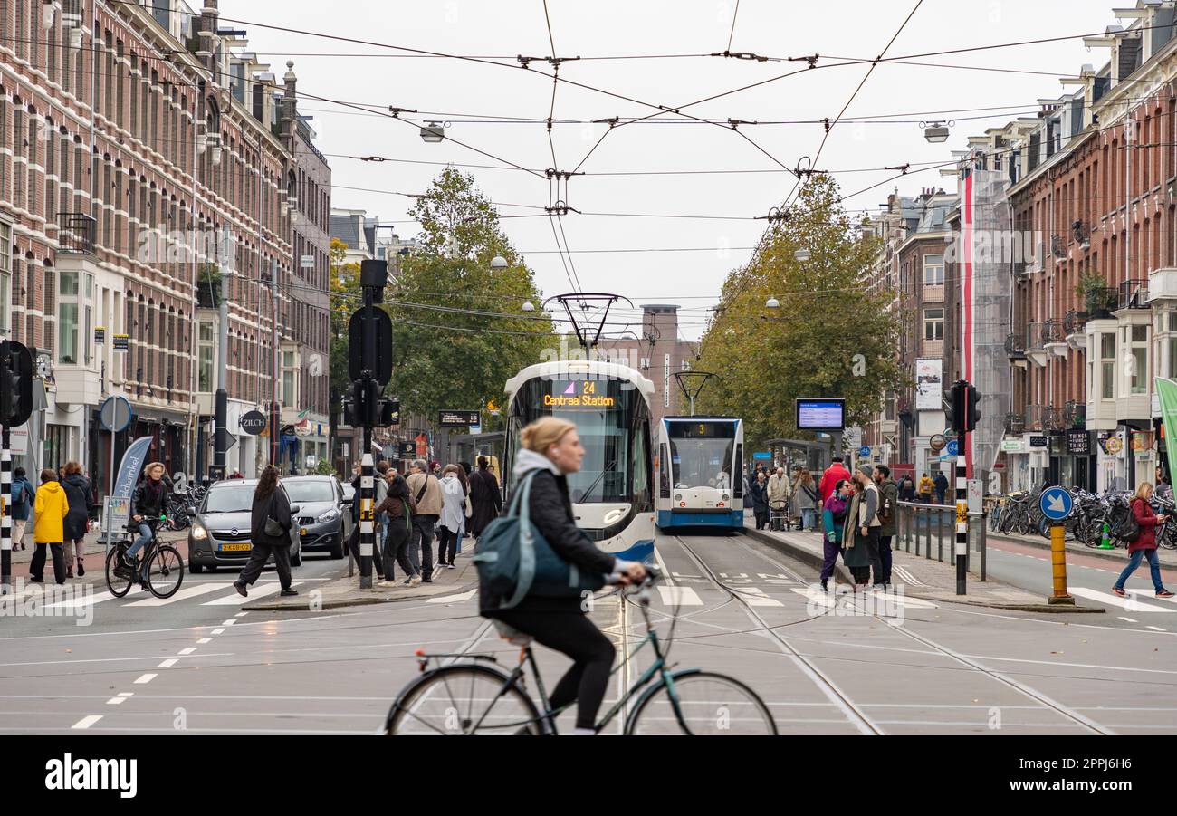 A picture of an intersection in Amsterdam showing bike, tram, car and