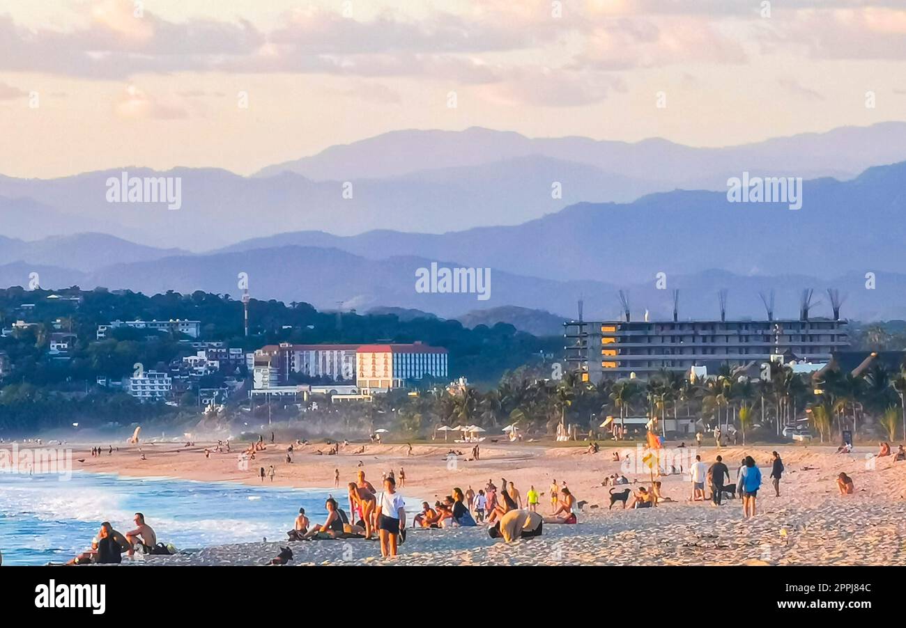 Colorful golden sunset people wave and beach Puerto Escondido Mexico. Stock Photo