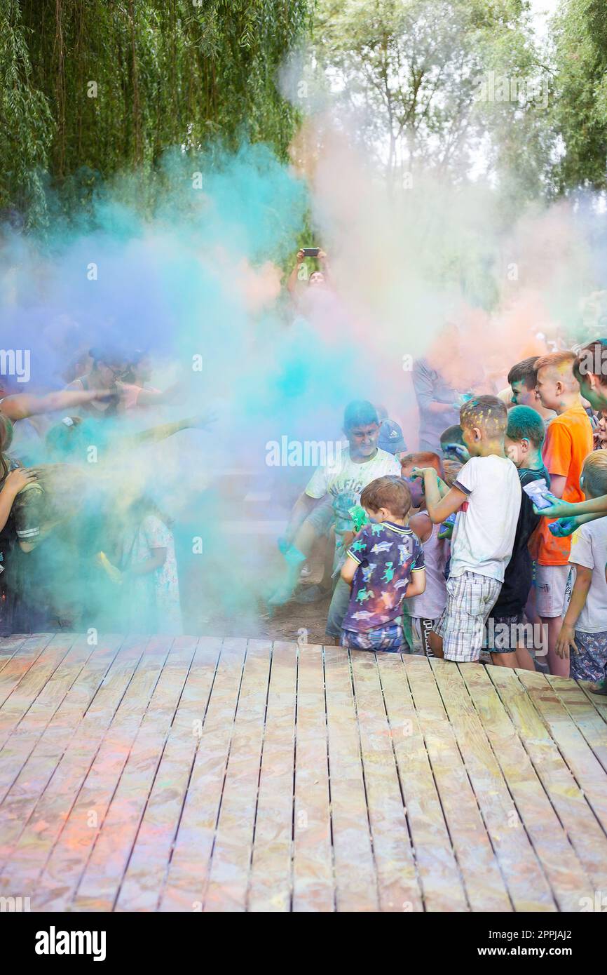 Lviv, Ukraine - July 18, 2021: Color Holi Festival, a crowd of people adults and small children throw colorful paint. Indian holiday. Stock Photo