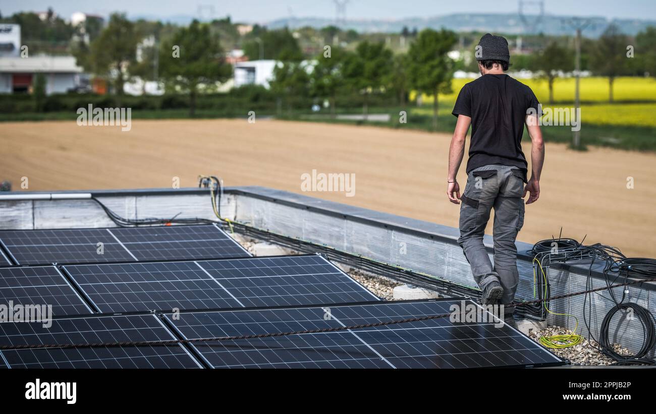 Male team engineers installing stand-alone solar photovoltaic panel ...