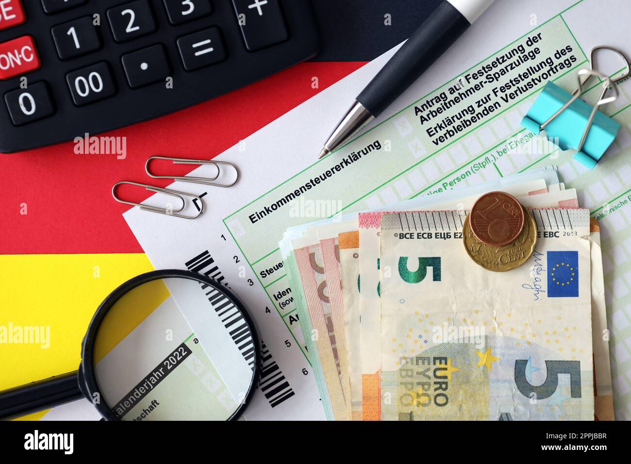 German tax return form with pen and european euro money bills lies on flag close up