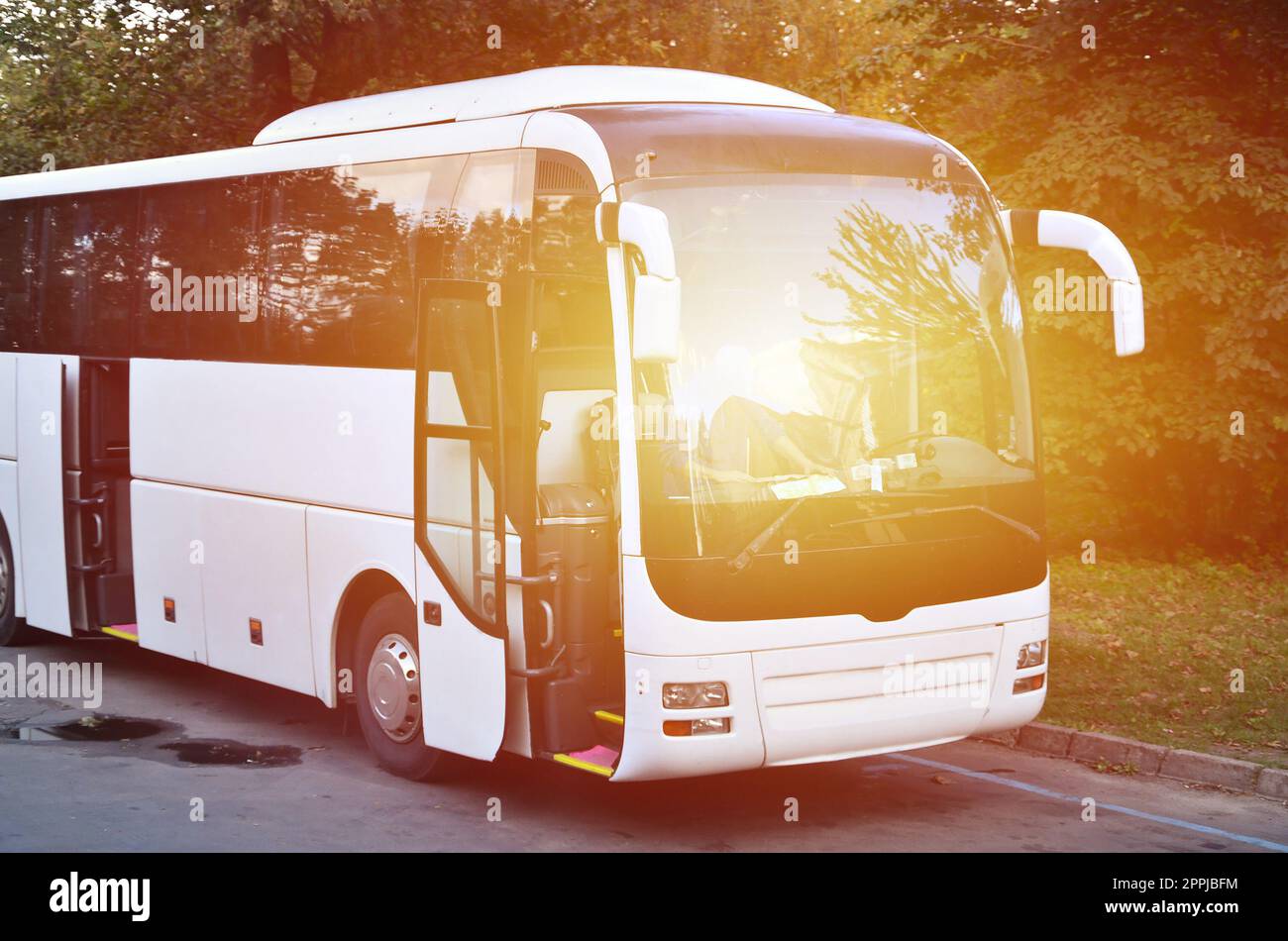 White tourist bus for excursions. The bus is parked in a parking lot near the park Stock Photo