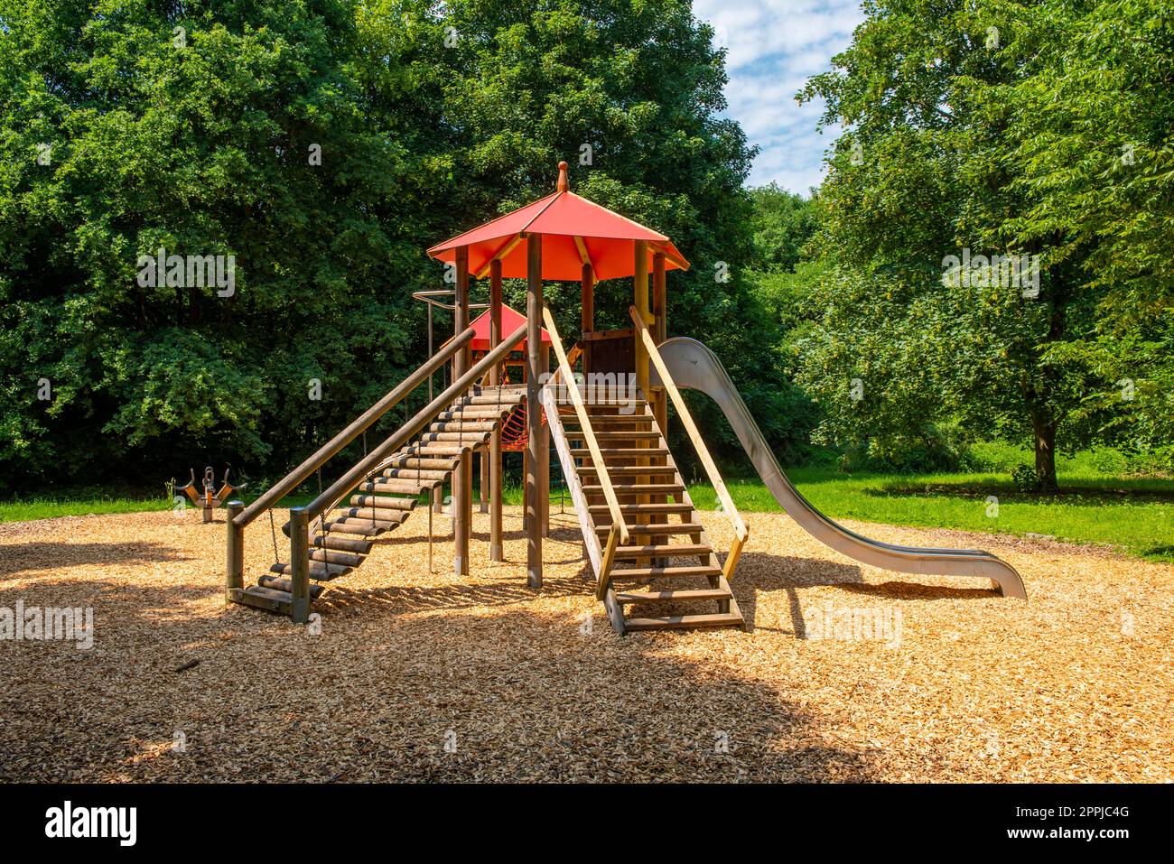 A wooden climbing castle with towers, palisades, slides, ropes and balancing bars on a deserted adventure playground Stock Photo