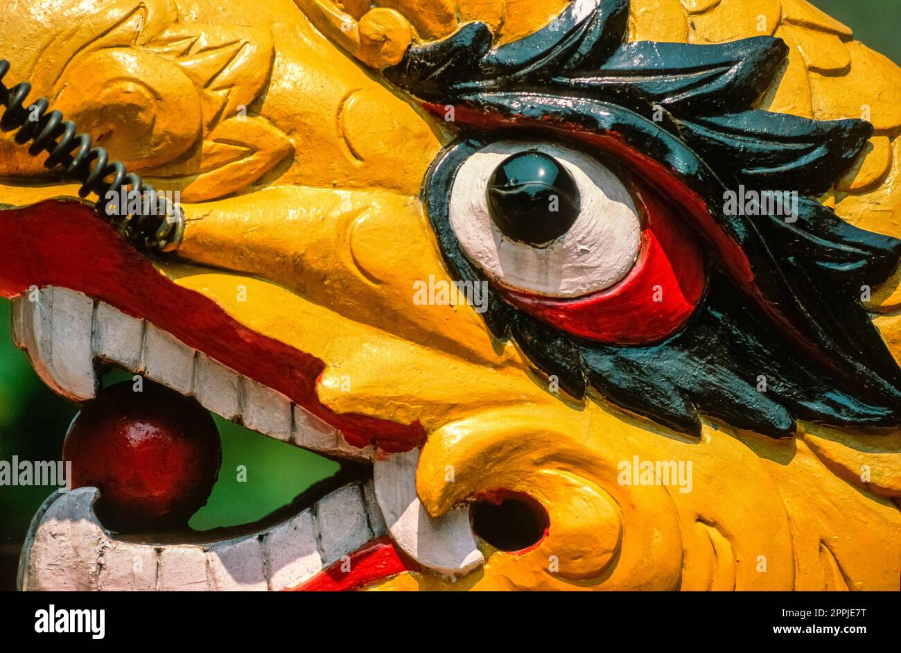 Scanned slide of a historical color photograph of a dragon head located on a staircase railing in Vietnam Stock Photo