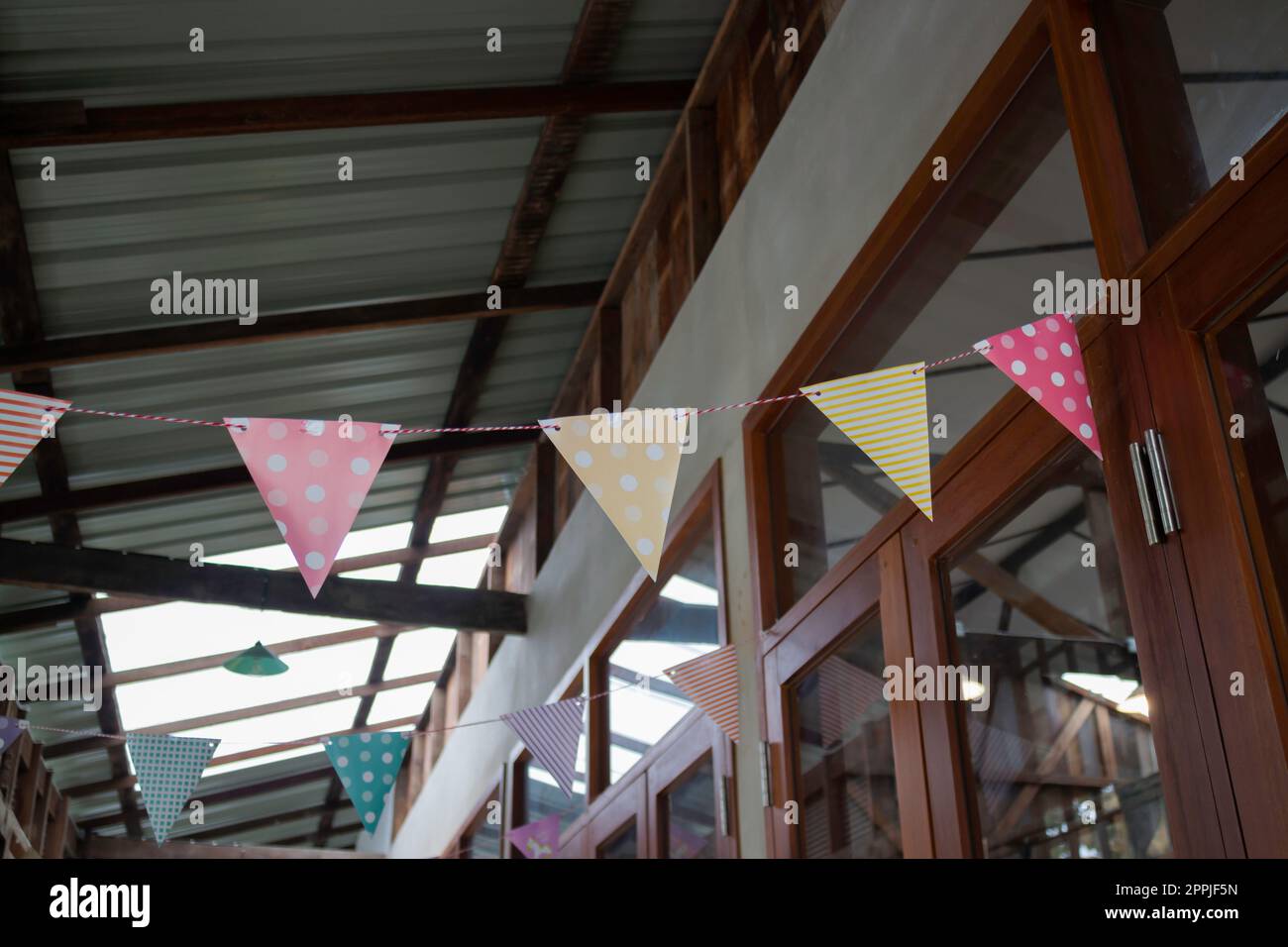 Festive colorful flags decorated on wooden architecture Stock Photo