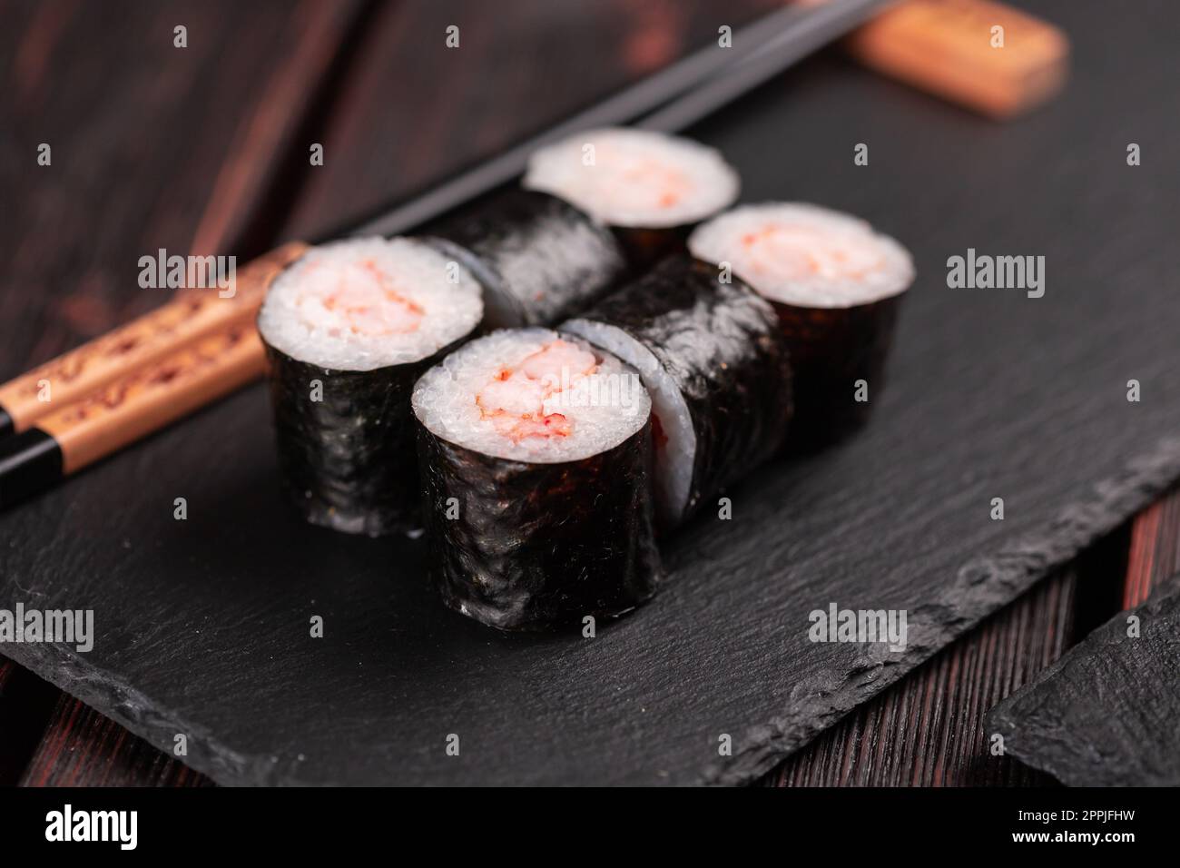 Maki shrimp sushi closeup. Shrimp fillet stuffing wrapped in rice and