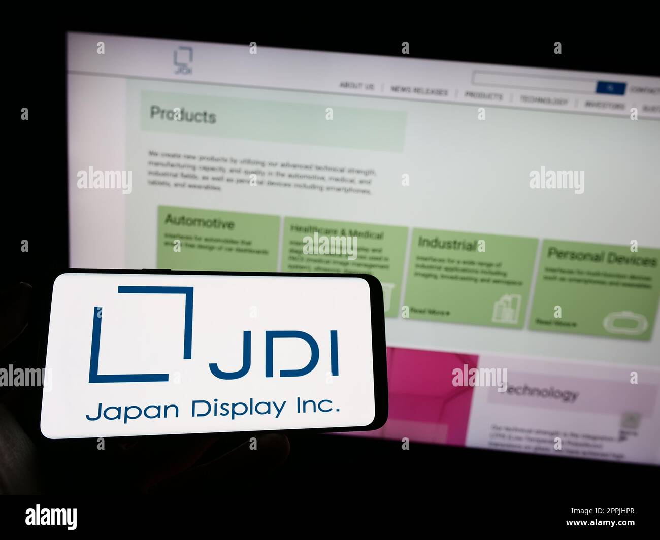 Person holding mobile phone with logo of electronics company Japan