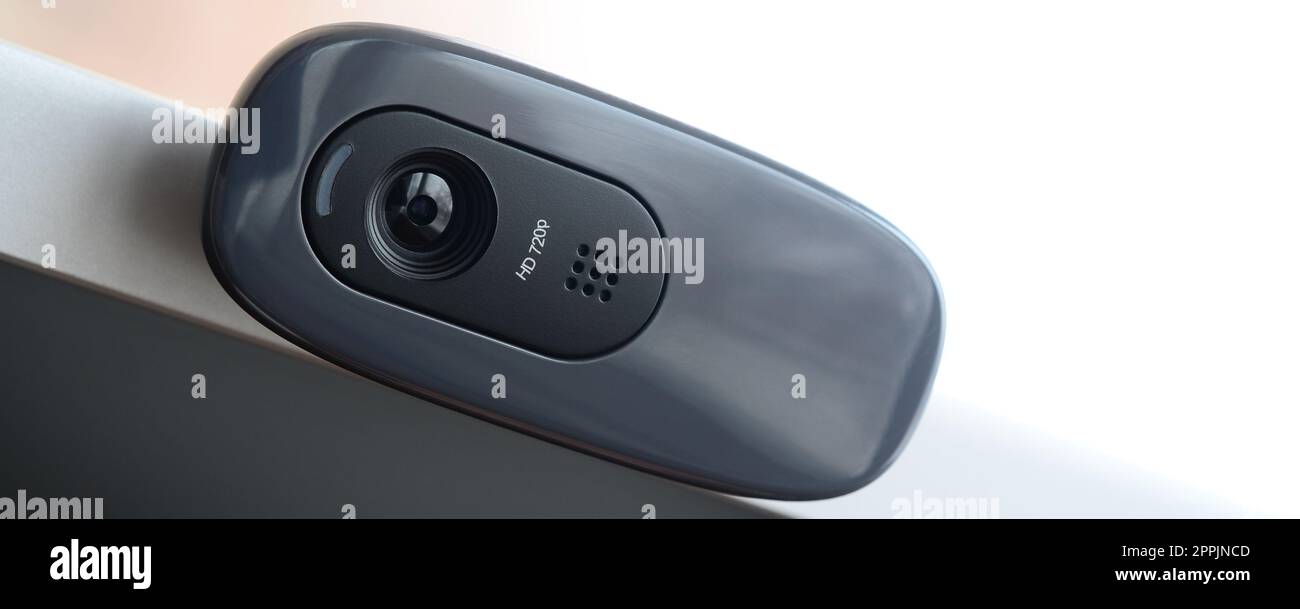A modern web camera is installed on the body of a flat screen monitor