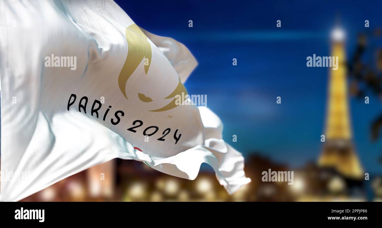 Paris 2024 Olympic flag waving with blurred Paris skyline at night
