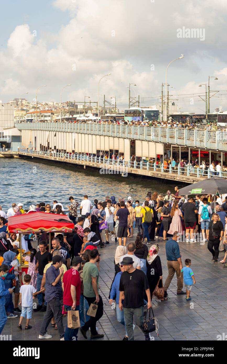 Crowds of pedestrians at Eminonu Plaza during Victory Day holiday with Galata Bridge in the background, Istanbul, Turkey Stock Photo