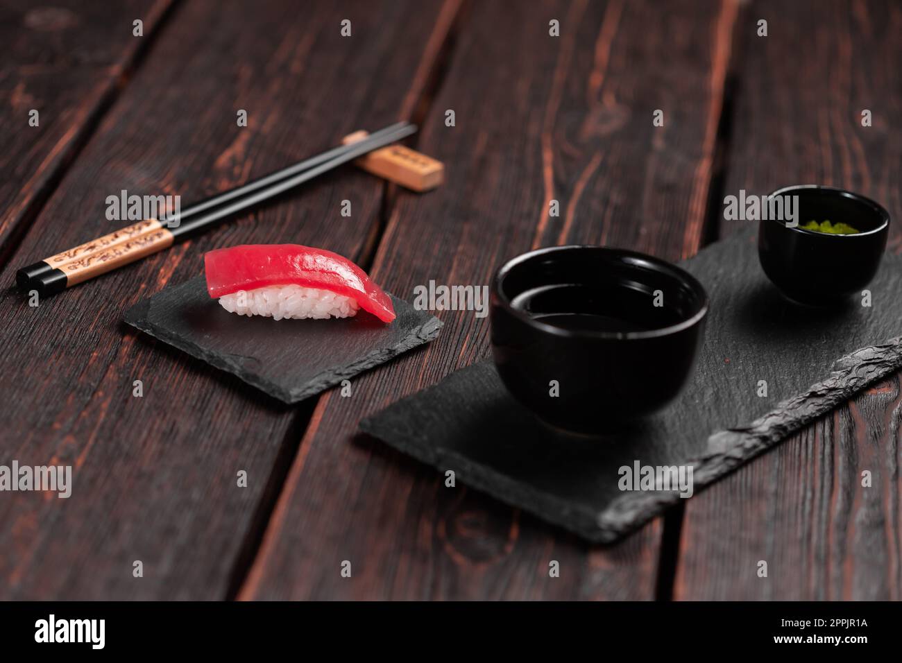 Delicious sushi maguro tuna. Nigiri with tuna on black and wooden background . Traditional Japanese cuisine Stock Photo