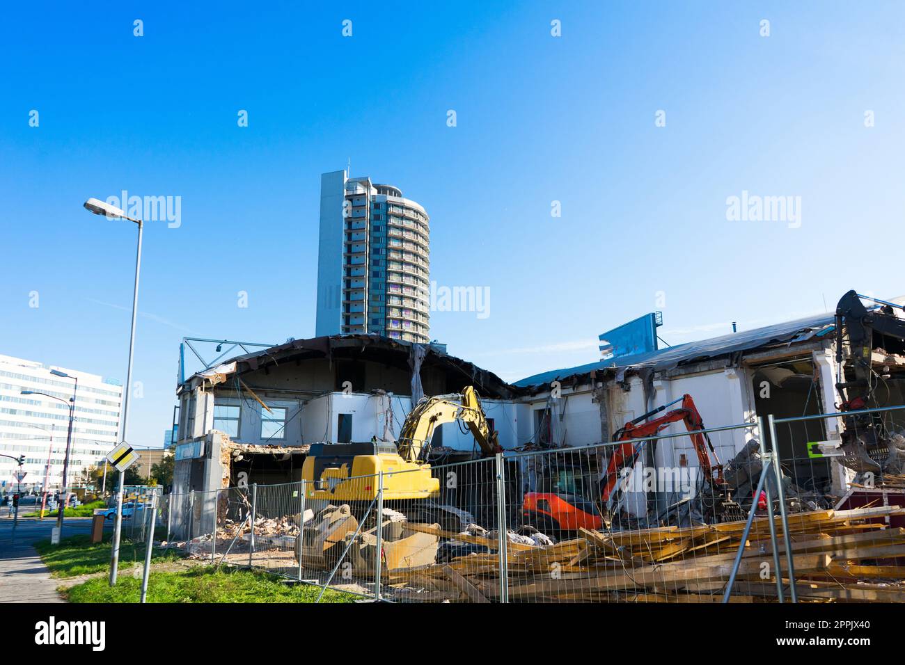 Demolition of the old building with sloopkraan against blue clouds sky ...