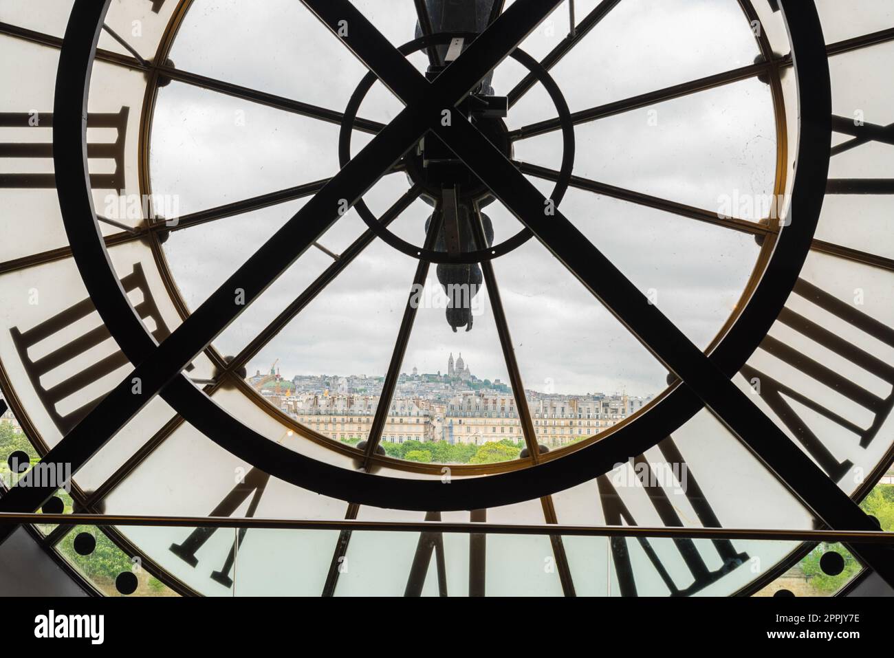 View of church Sacre Coeur in Montmartre through a large Clock from Museum d'Orsay in Paris Stock Photo