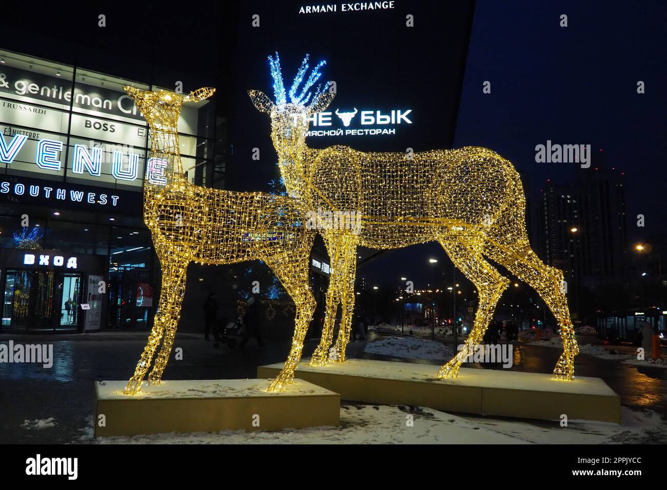 Moscow, Russia, January 17 2023 Metro Yugo-Zapadnaya. Christmas decorations in front of the mall. New year street decorations in the form of sparkling deer. Deer figure made from yellow gold garlands. Stock Photo