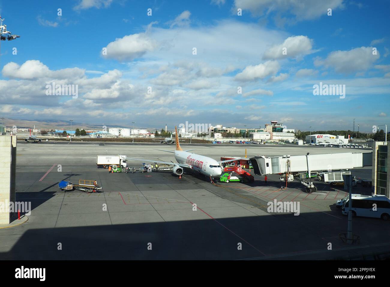 Ankara, Turkey, Esenboga Havalimani Airport, 01.19.2023. view from the window of the passenger terminal on the runway area. Airplane bridge. Passengers with suitcases disembark from the plane. Sky Stock Photo