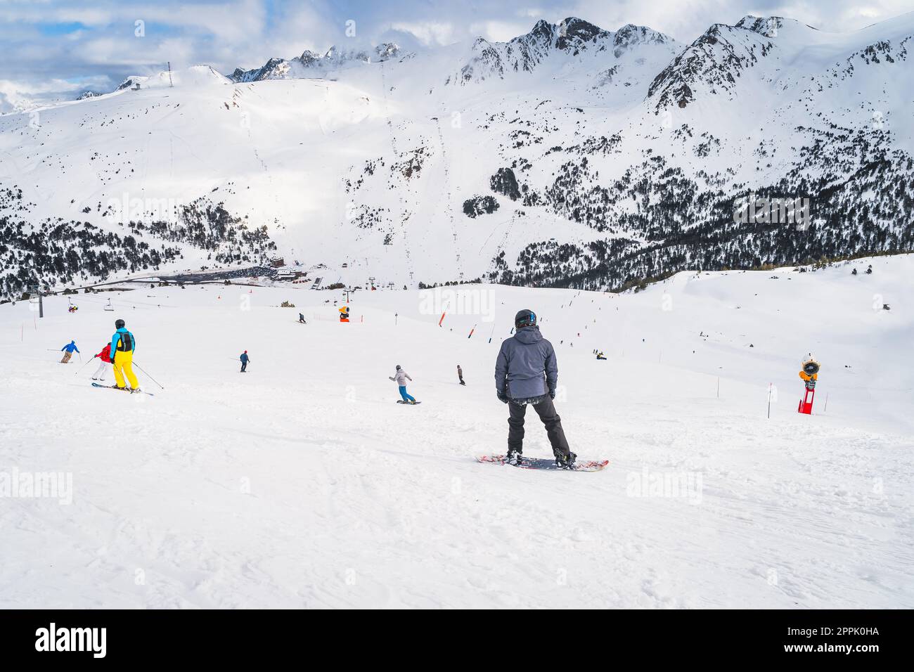 Snowboarders and skiers riding down the mountain, Andorra, Pyrenees Stock Photo