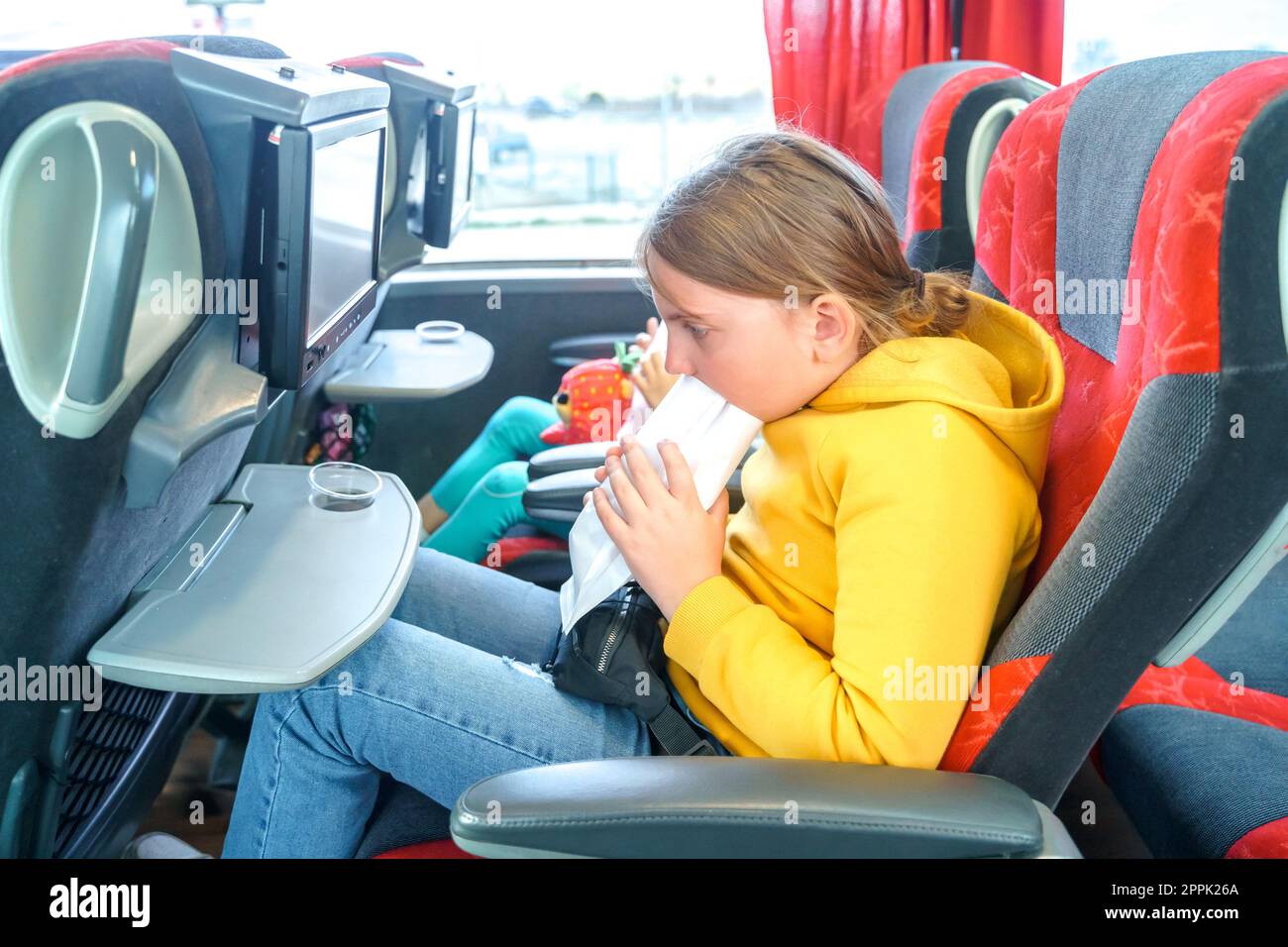 Girl is sick, vomits in bag. Bus road traveling. Girl kid feels bad