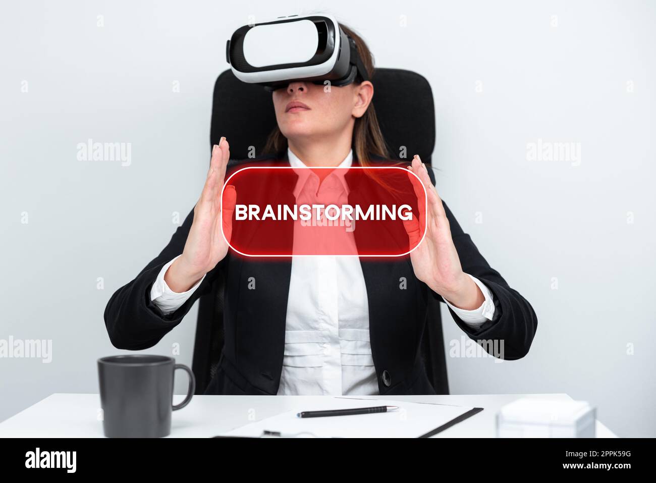 Hand writing sign Brain Storming. Business concept Long term marketing support for a product Marketing Executive Gesturing And Learning Skill Through Virtual Reality Simulator. Stock Photo