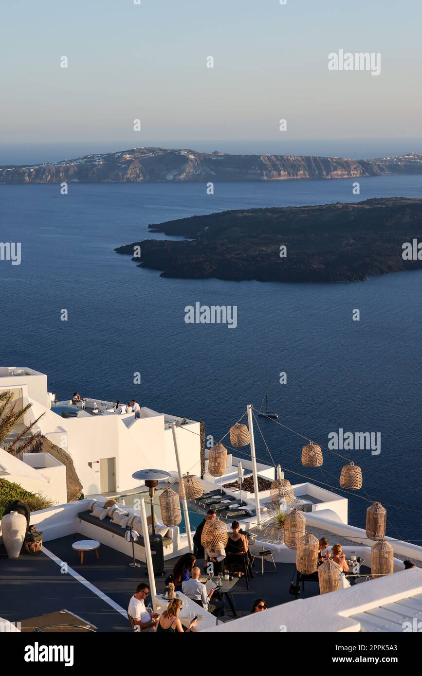 Tables on the restaurant terrace with a picturesque view of the sunset in Imerovigli. Santorini Stock Photo