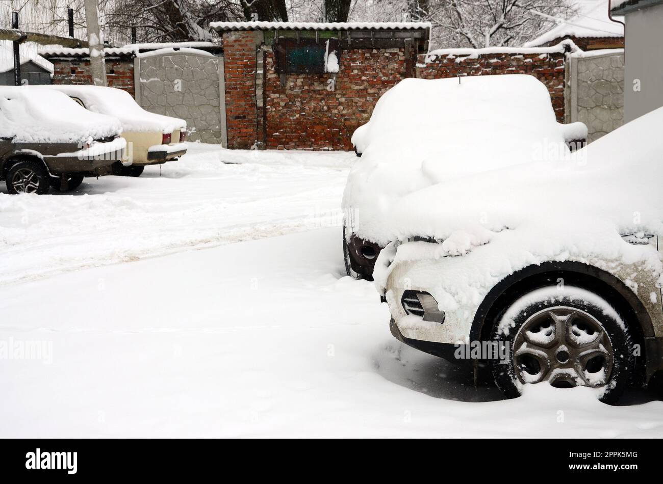 Fragment of the car under a layer of snow after a heavy snowfall. The body of the car is covered with white snow Stock Photo