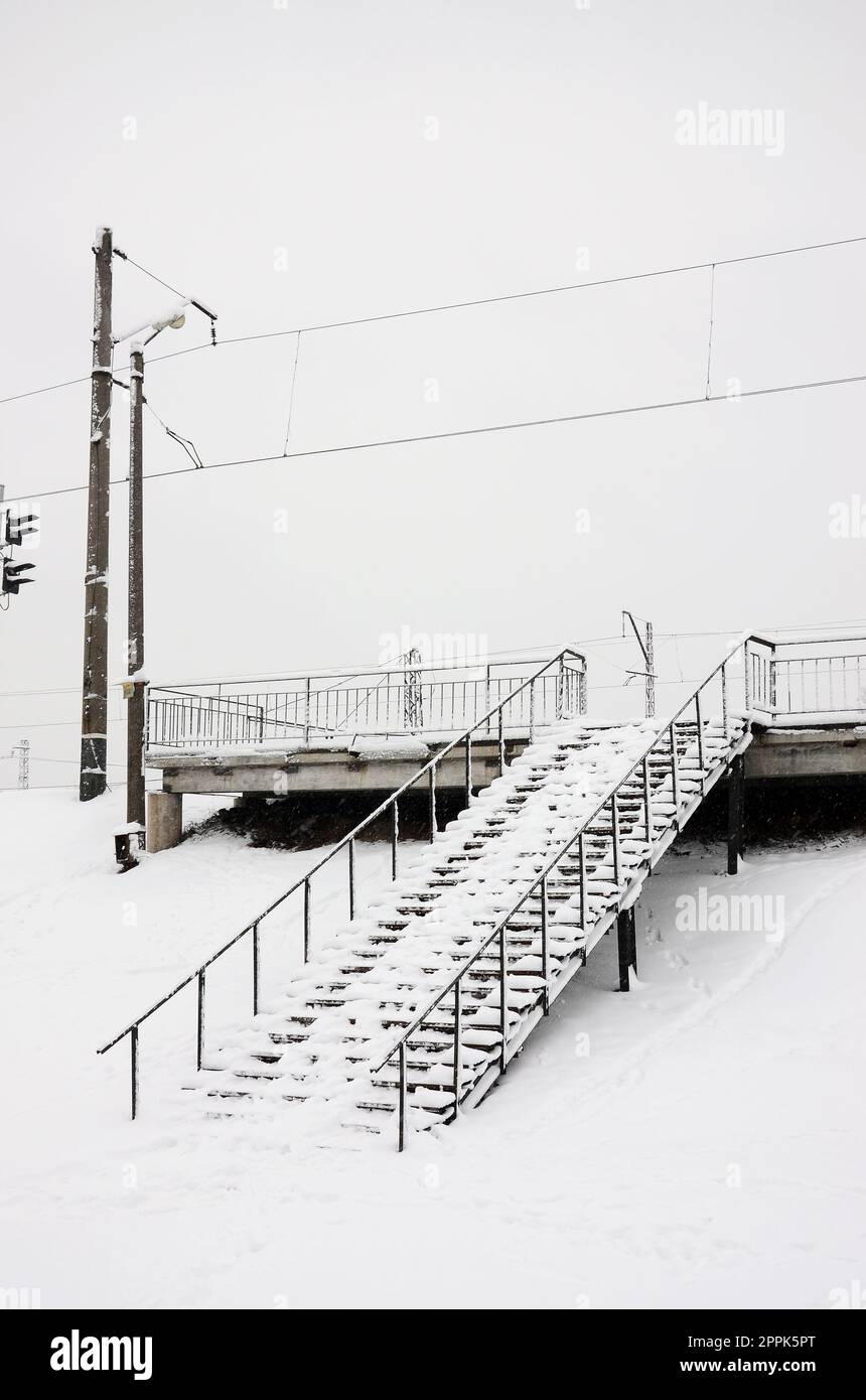 Metal steps leading to the railway station. The steps are covered with snow after a heavy snowfall Stock Photo