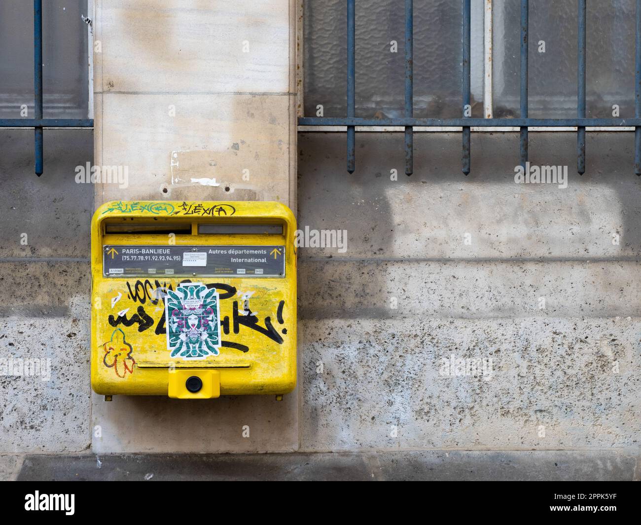 Graffitied and pasted mailbox at a post office in Paris Stock Photo