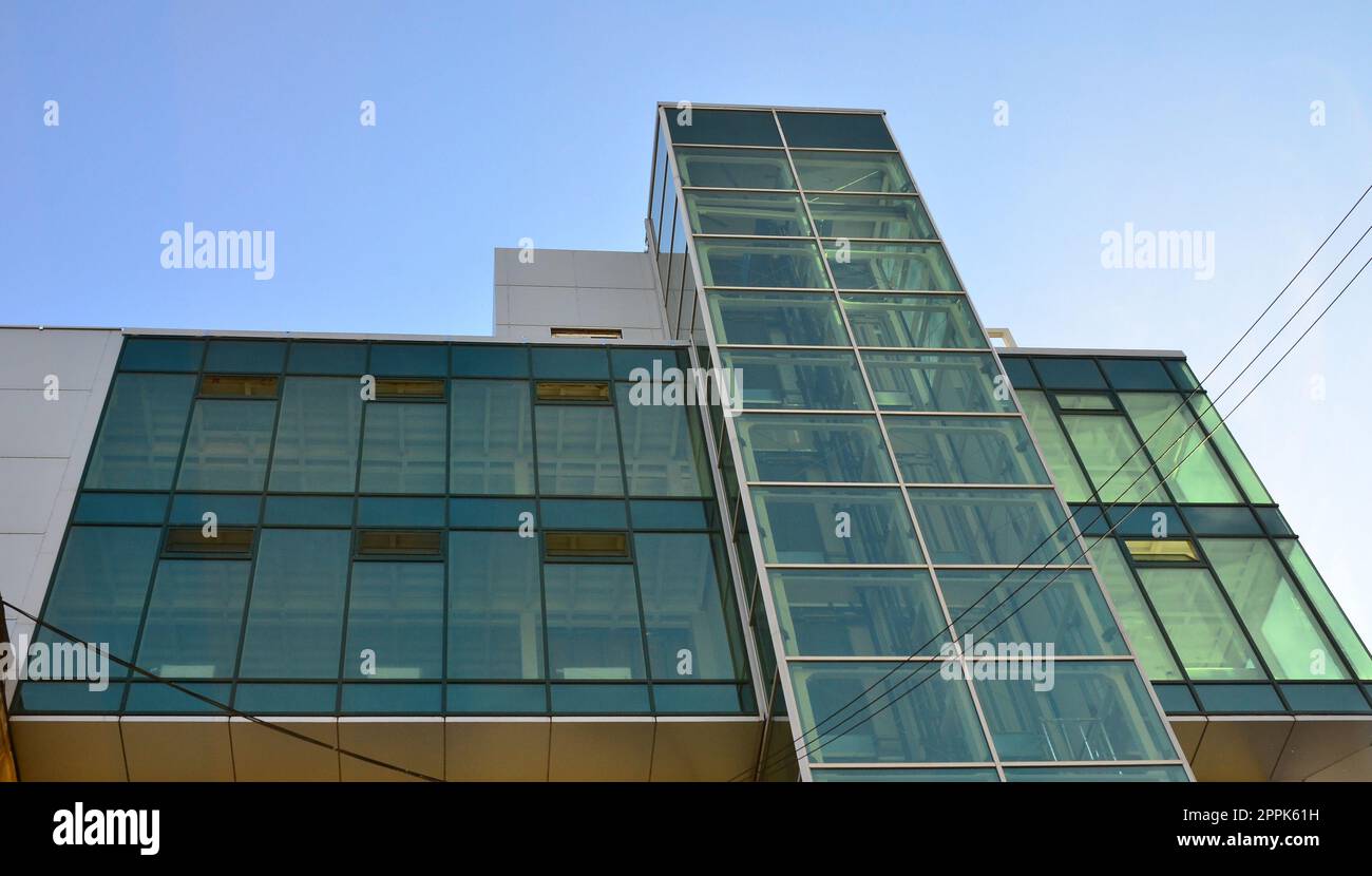 Modern office building with glass transparent walls against the blue sky Stock Photo