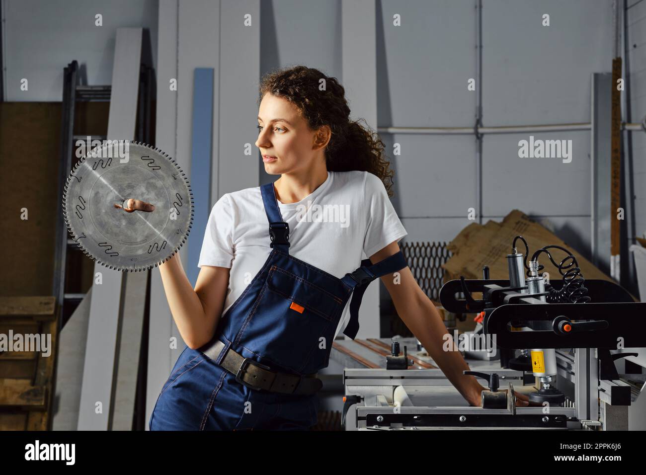 Craftswoman holds a circular saw blade in hand Stock Photo