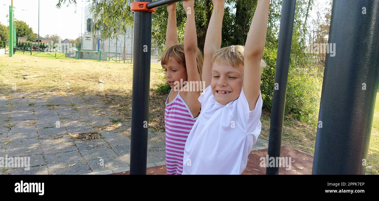 Sremska Mitrovica, Serbia, September 13, 2020. A boy and a girl on the sports or playground are engaged in physical exercise. Child in a white t-shirt Stock Photo