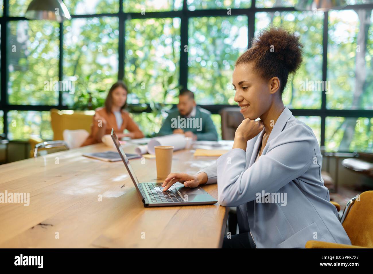 Young business woman working on laptop at shared open workspace Stock Photo