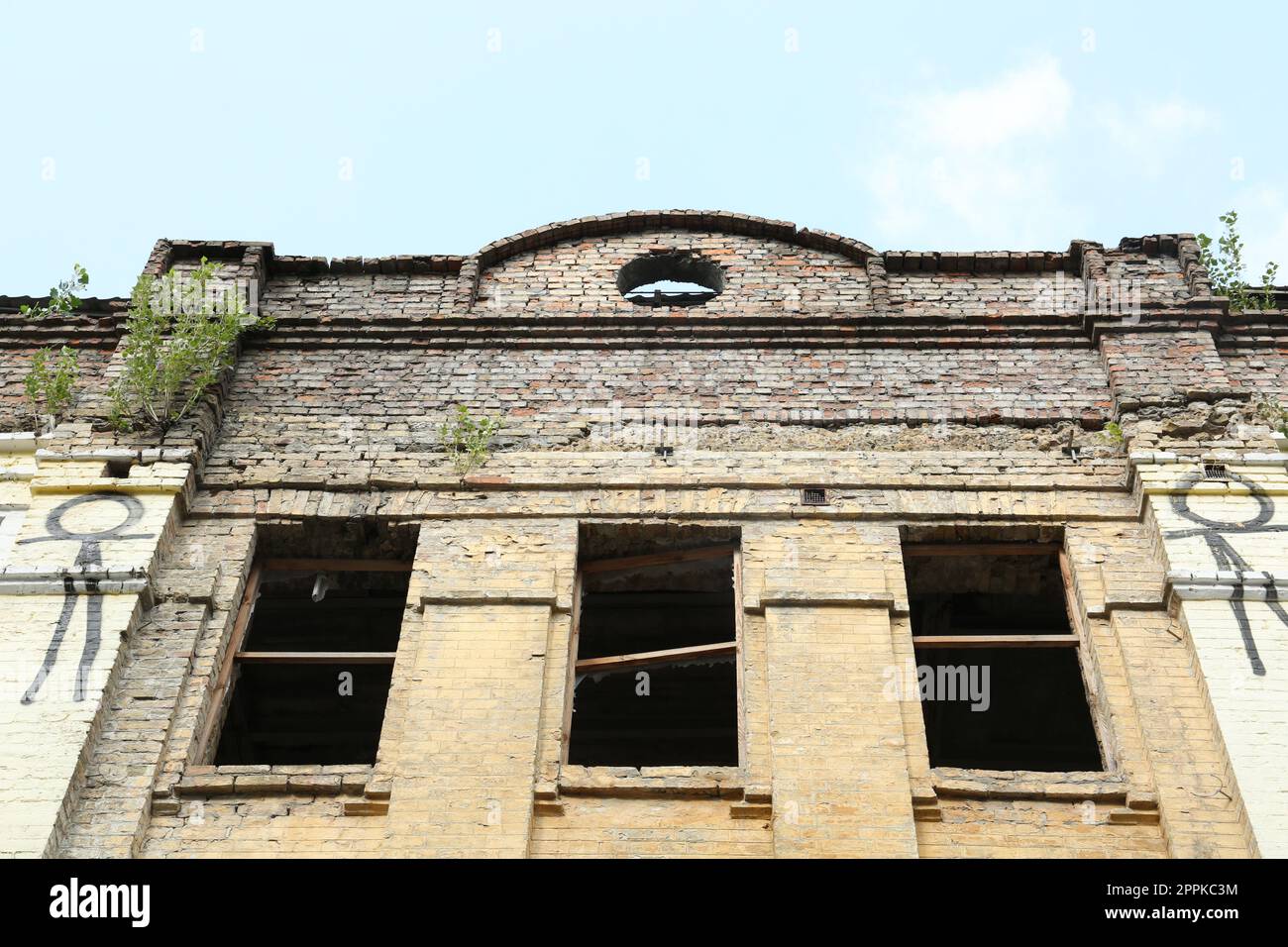Abandoned building with broken windows against blue sky, low angle view ...