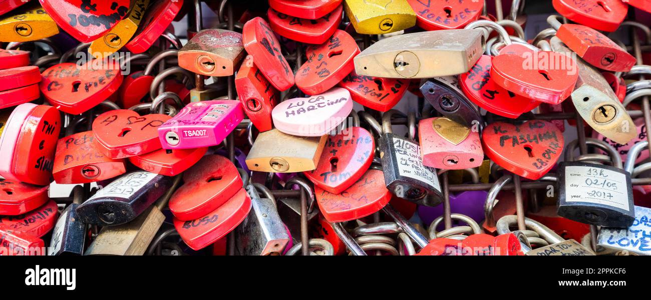 Verona, Italy - June 2022: background of heart-shaped locks on a wall, symbol of love forever. Stock Photo