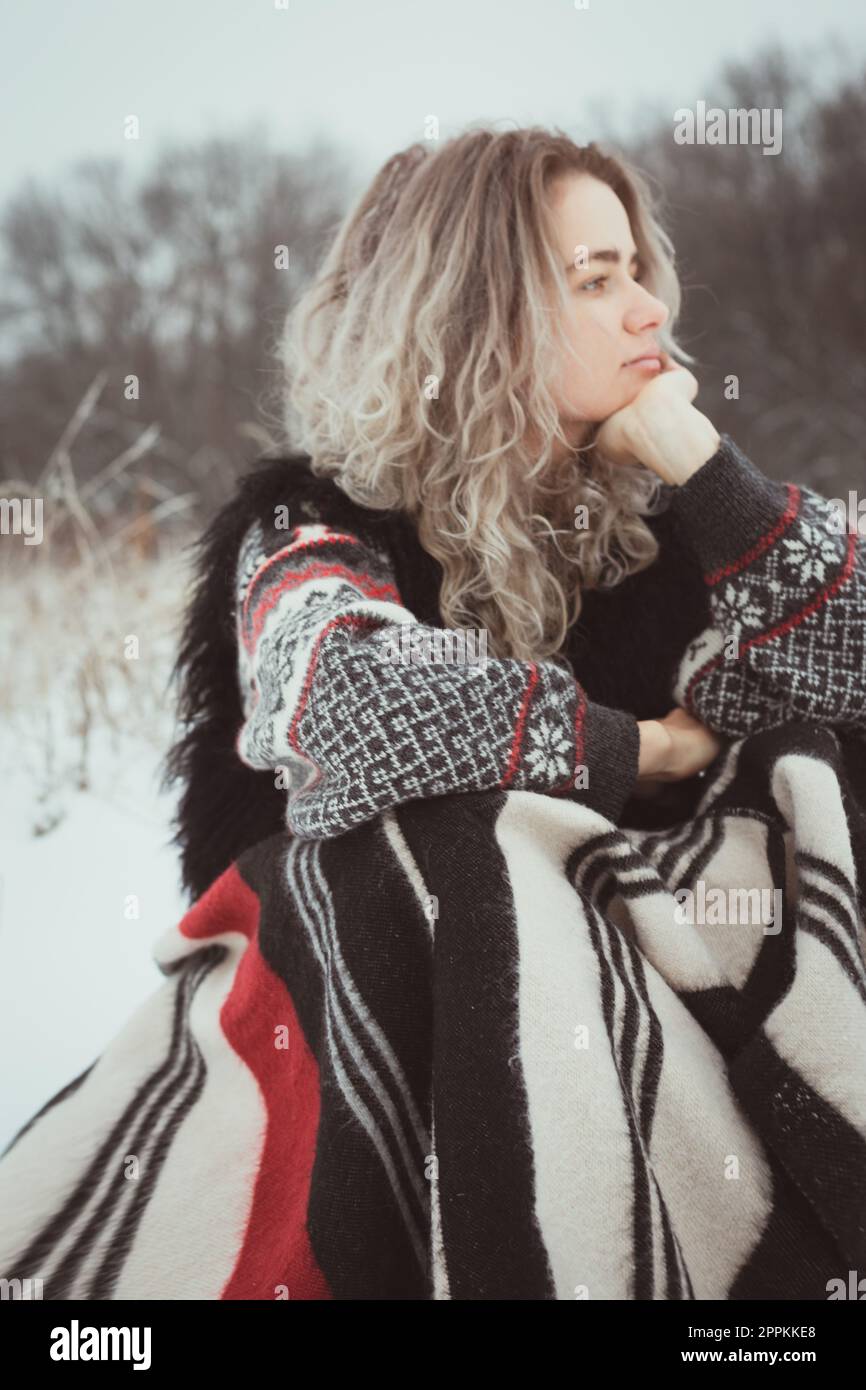 Close up pretty woman with warm blanket in snowy field portrait picture Stock Photo