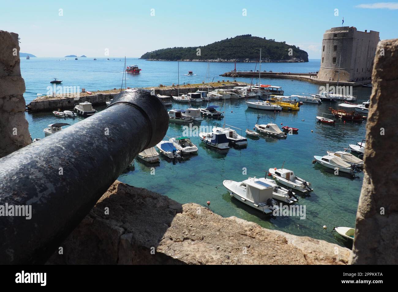Dubrovnik, Croatia, 08.14. 2022. City port summer tourist attraction. Tourists walk, get into boats and ships and go on boat trips. Adriatic Sea. Travel. Cannon muzzle. Private boats of local citizens Stock Photo