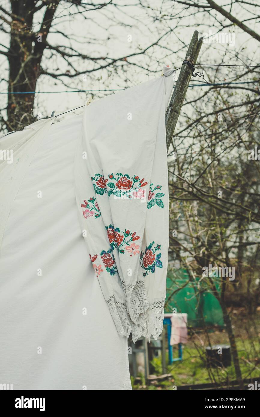 Close up ukrainian embroidered shirt hanging on clothesline concept photo Stock Photo