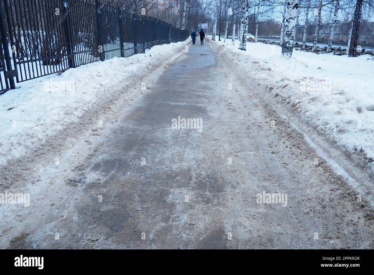 Petrozavodsk, Russia, 01.15. 2023 Snow, ice, slush and winter mud on the sidewalk. The air temperature is about 0. Difficult driving conditions. Infrastructure, road services. Pavement with wet snow Stock Photo