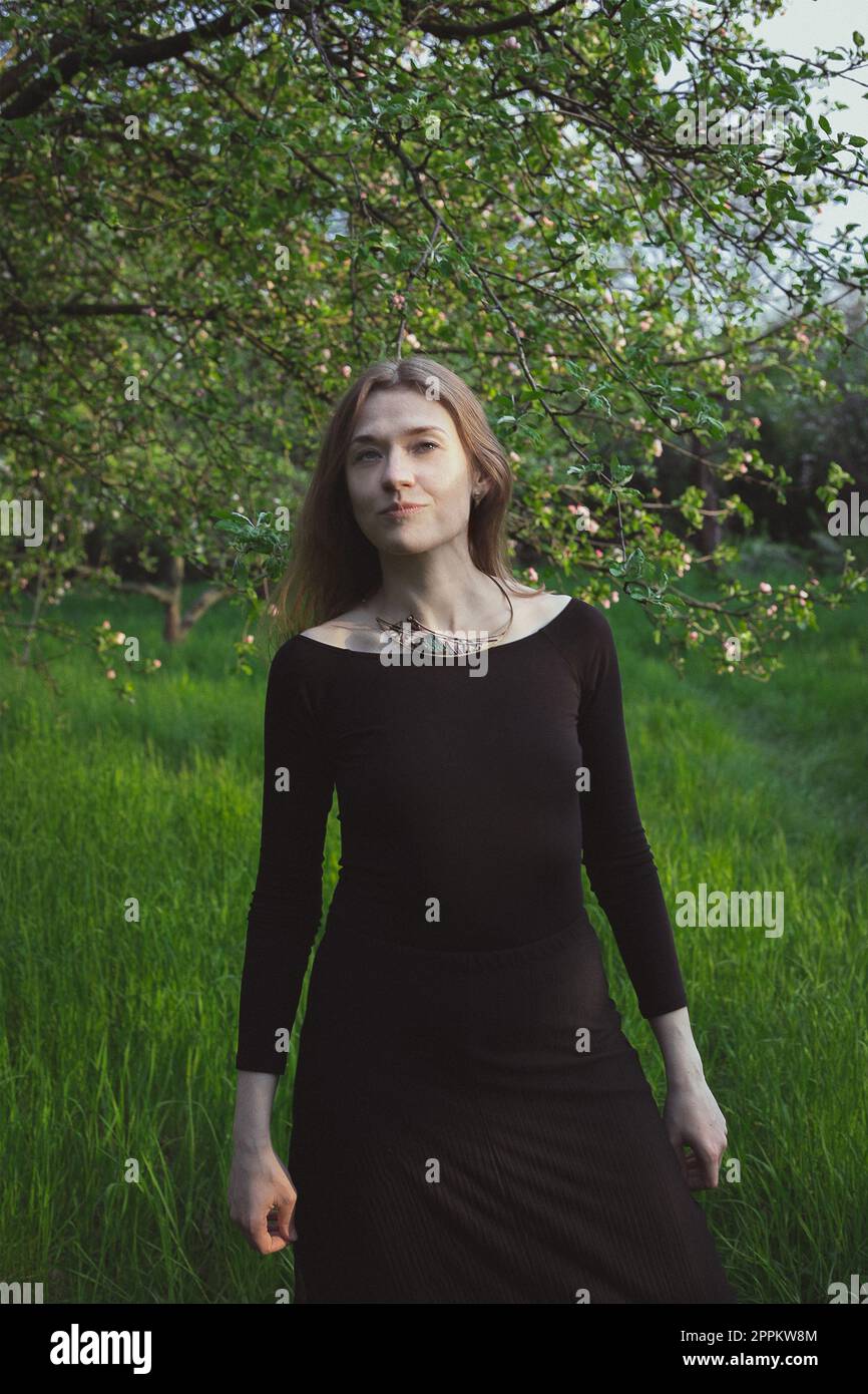 Woman wearing tight-fitting black dress in garden scenic photography Stock Photo