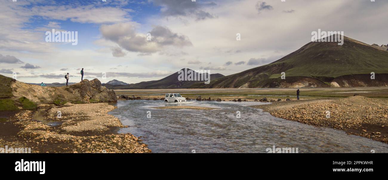 Car crossing shallow river landscape photo Stock Photo