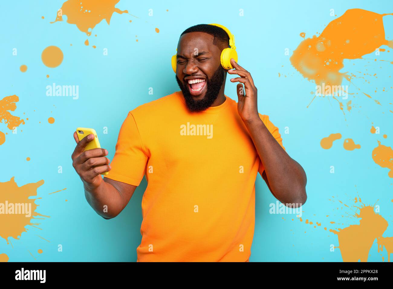 Boy with yellow headset listens to music and dances. emotional and energetic expression Stock Photo