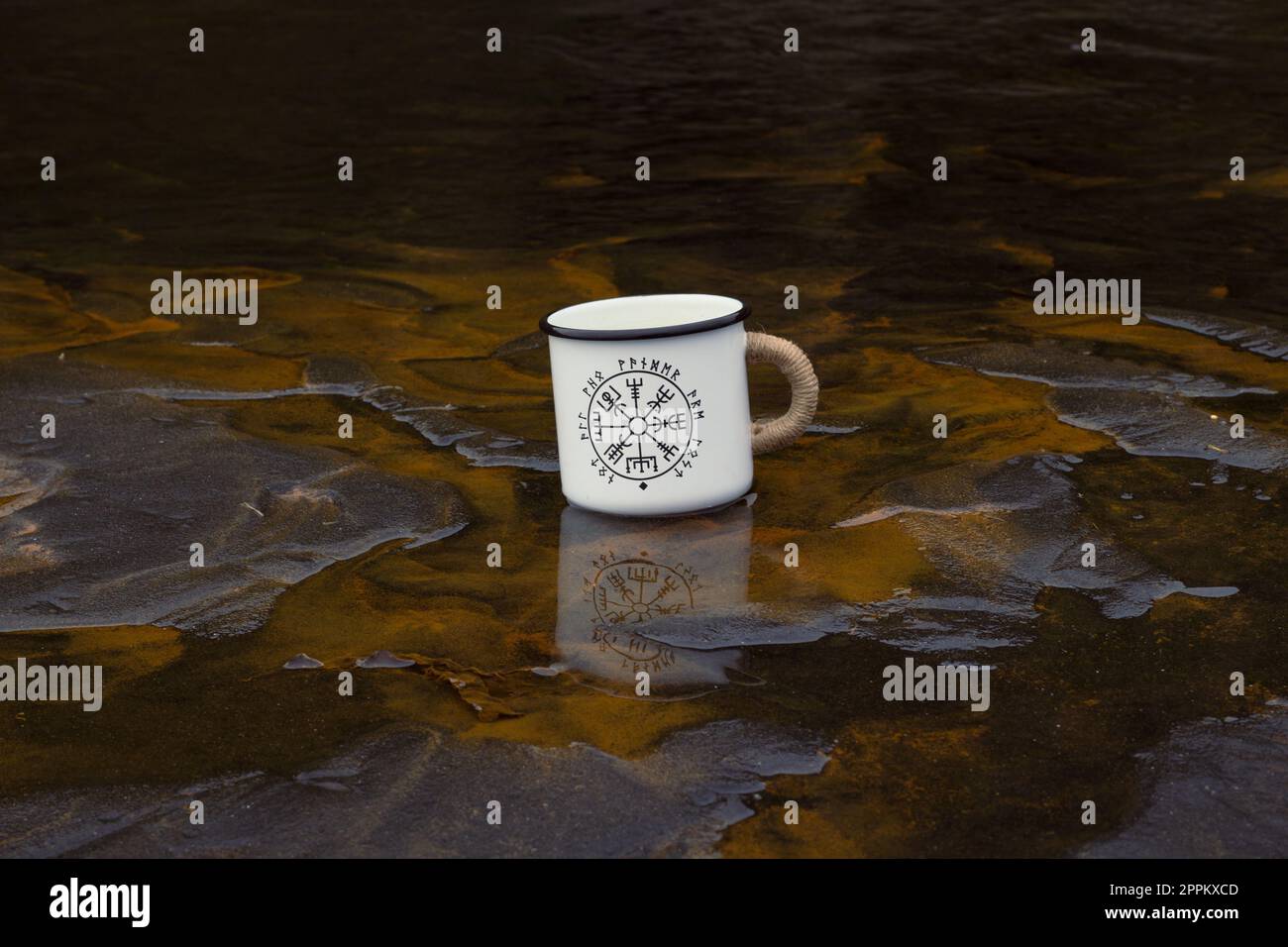 Close up tourist mug in shallow river concept photo Stock Photo